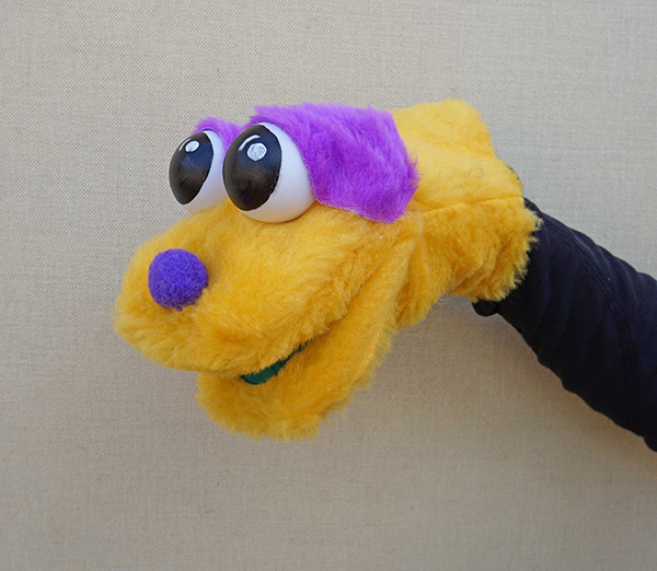 Títere bocón amarillo con ojos saltones y cejas y nariz morada