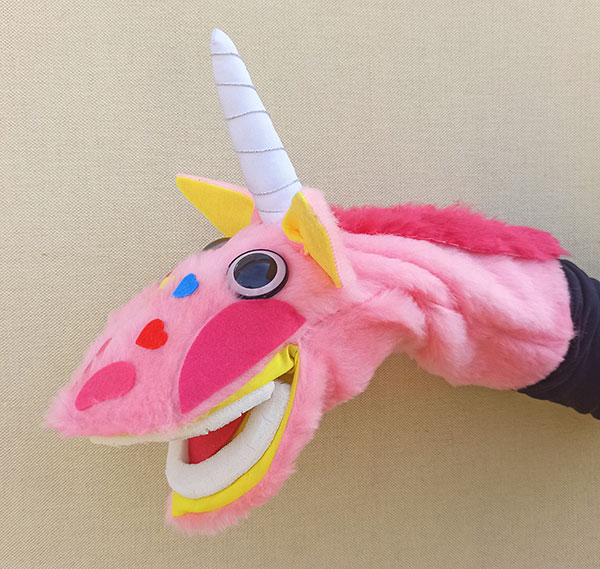 Títere de unicornio rosa que abre la boca